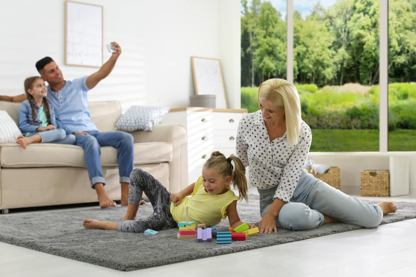 Des parents et leurs enfants dans leur salon, devant les outils de calcul d'un rachat de crédit