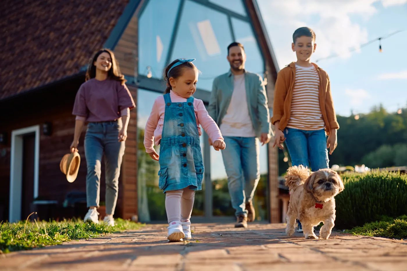 Une famille et son chien devant leur maison, profils éligibles au rachat de crédit