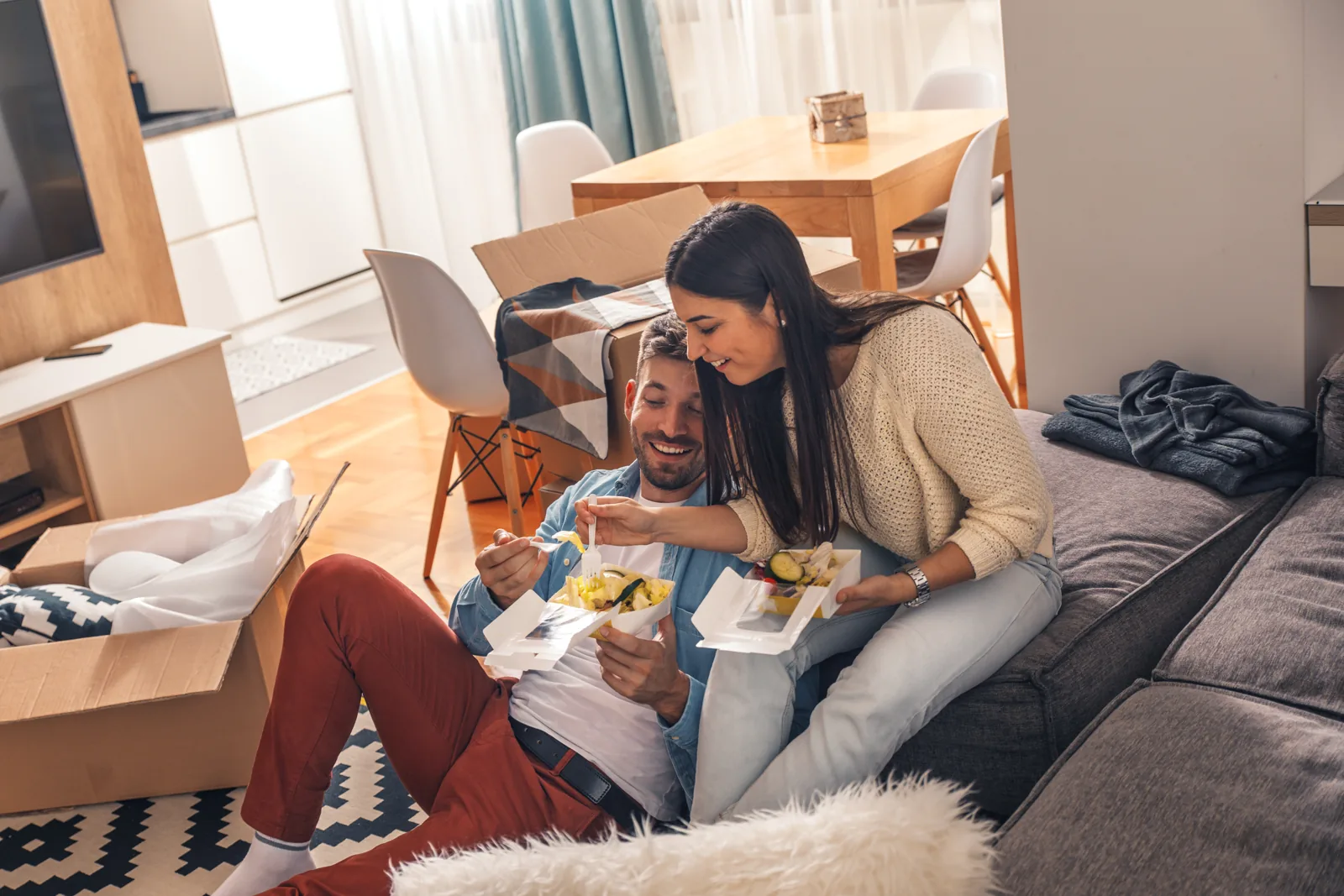 Un couple installé dans son nouveau logement, illustration d'un rachat de crédit à la consommation